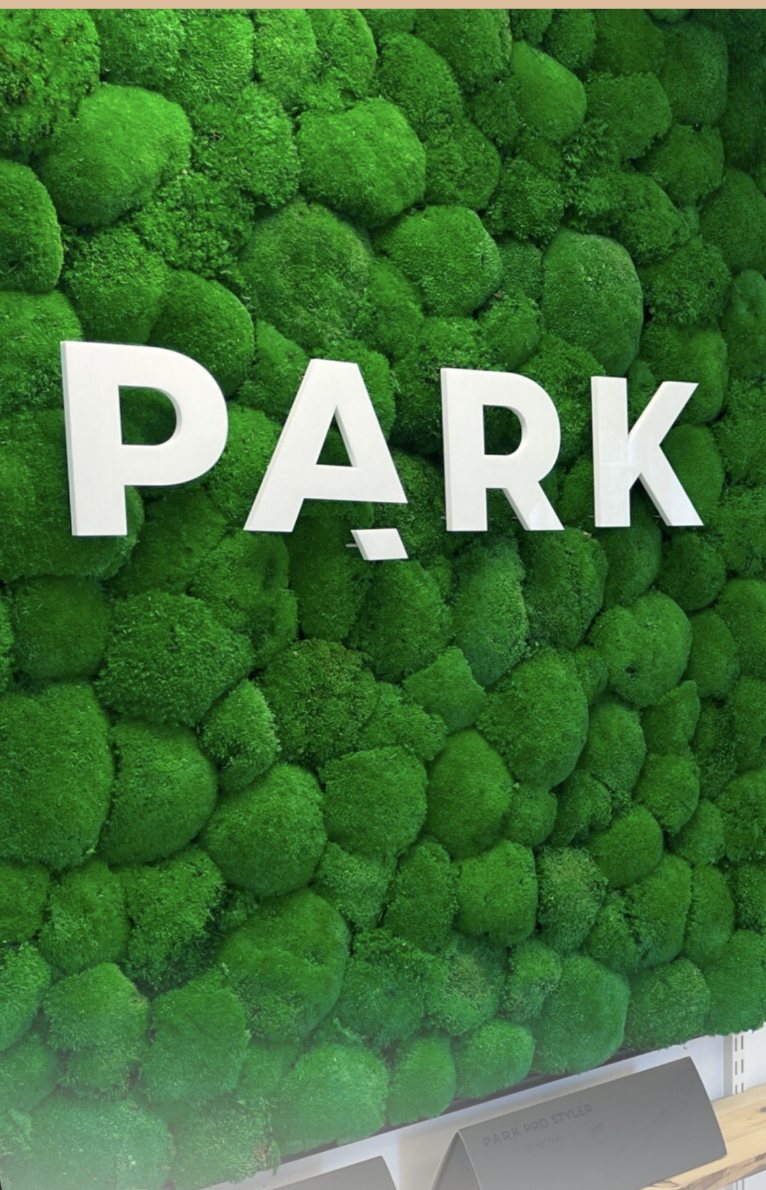 Grøn mosvæg med PARK-logo i salonen